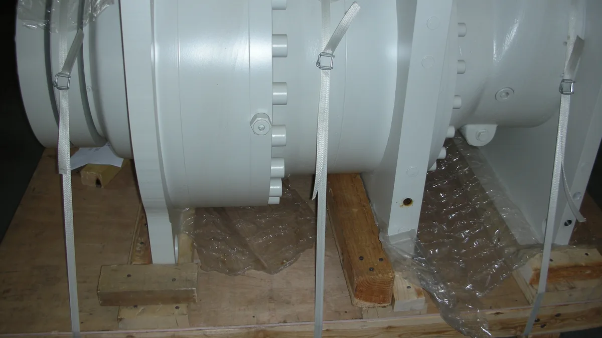 Machine housings strapped to wooden crate bases with cord strapping and buckles